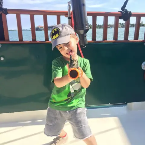 A kid plays with a toy pirate gun